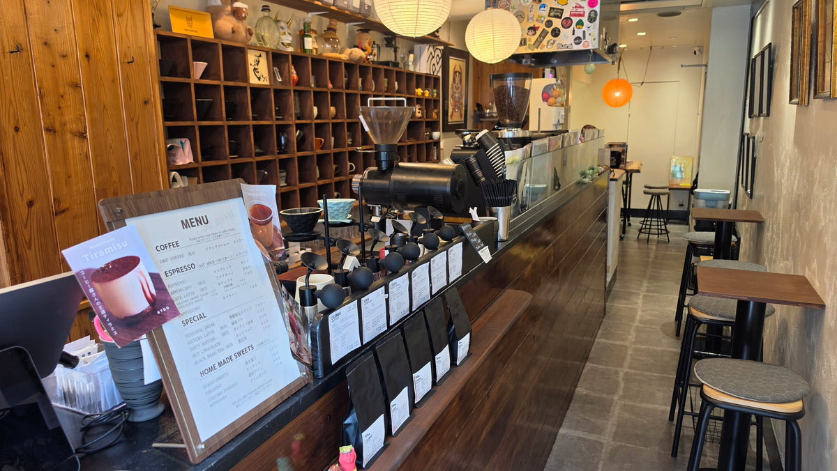 Inside Oni Coffee: the espresso bar and counter with bags of roasted coffee on the shelves
